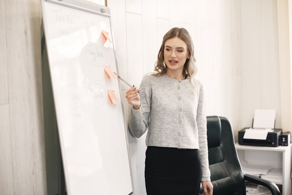 Professional woman giving a presentation using a whiteboard in an office setting.