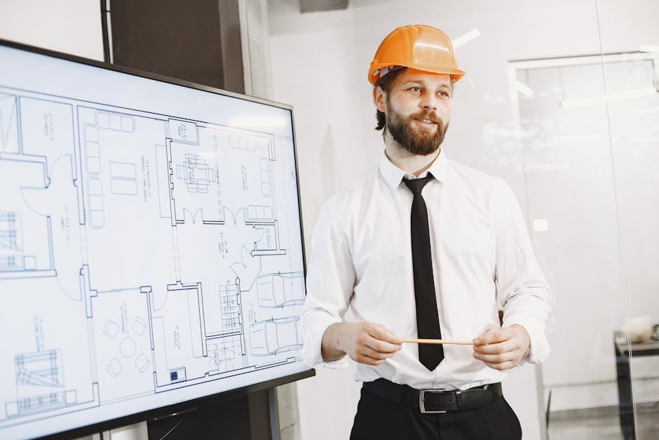 Architect in orange helmet presenting building blueprints in a modern office setting. Professional and confident.